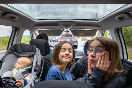 Kids in car. Funny faces. Baby on a road trip.の写真素材