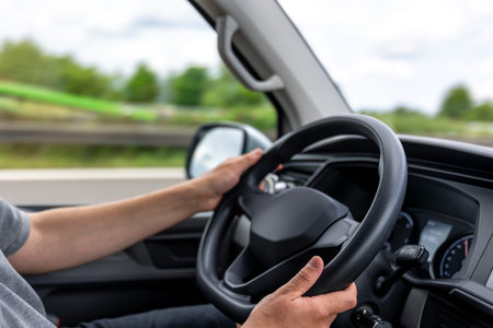 Hands on steering wheel. Driver holding wheel. Car control in motion.