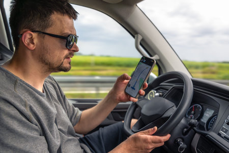Driver with phone. Using navigation. Highway movement.の写真素材