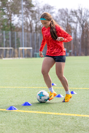 Girl on the soccer field. Soccer training. Active lifestyle. Football concept.