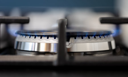 Close-up gas burner. Blue flame. Stylish kitchen macro.