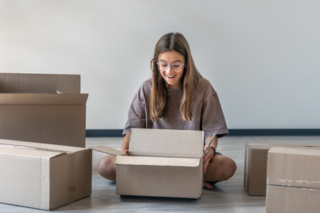 Girl unboxing parcel. Joy of discovery. Eco boxesの写真素材