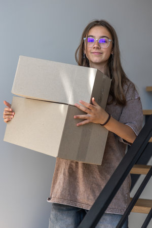Girl carrying boxes. Moving at home. Modern styleの写真素材