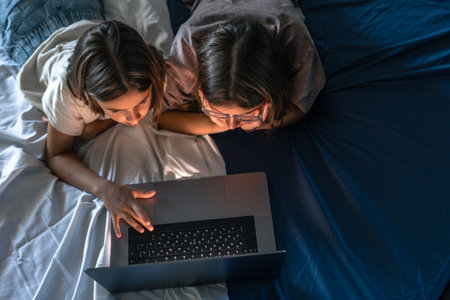Two girls with laptop. Modern kids technology. Online fascinationの写真素材