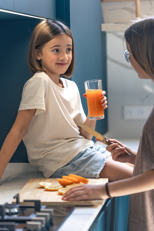 Orange juice at home. Girl in kitchen. Morning routineの写真素材