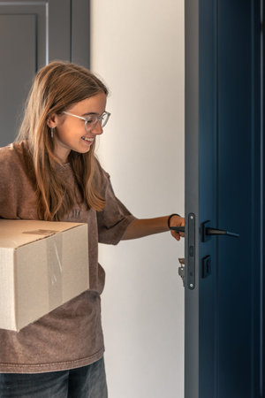 Opening door with parcel. Home delivery. Everyday styleの写真素材