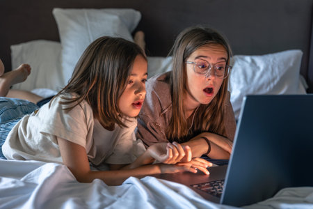 Girls watching laptop. Modern teens at home. Surprise and emotions