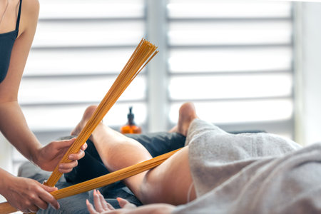 Percussive bamboo whisk massage for smooth skin. Thigh drainage.の写真素材