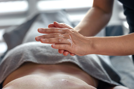 Relaxing massage with essential oils in modern spa. Massage hands close-upの写真素材