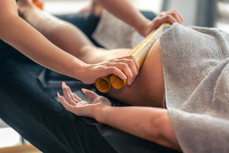 Bamboo thigh massage in a modern spa. Bamboo massage.の写真素材