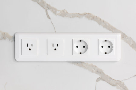 Modern wall outlets. Euro and US standards. Marble background.の写真素材