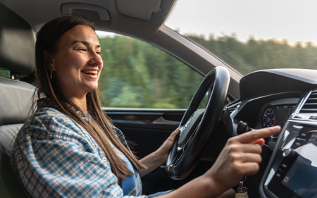Smiling woman driving car and using navigation. Journey with modern technology