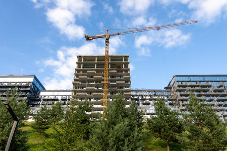 Construction site with tower crane and apartments. Urban modern architecture