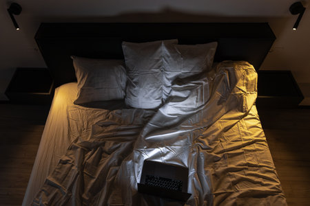 Overhead bed with laptop in warm and cool lighting. Night work.の写真素材