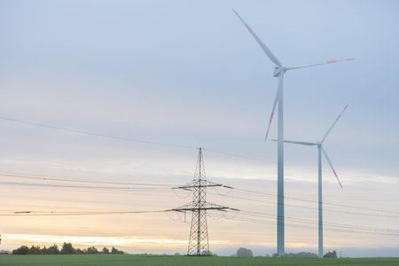 Wind turbines and power lines at sunrise. Clean energy.