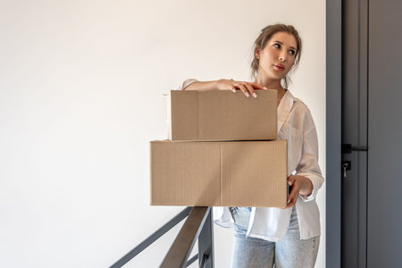 Young woman with boxes on railing in bright hall. One person, shopping.