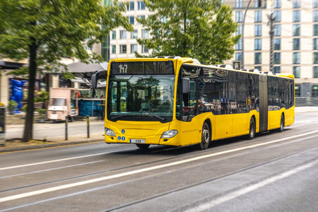 Yellow articulated city bus downtown. Public transport.