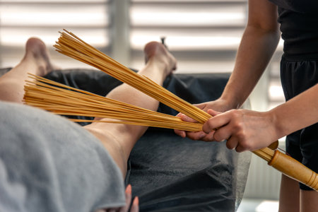 Bamboo whisks over calf in daylight spa. Drainage and tone.の写真素材