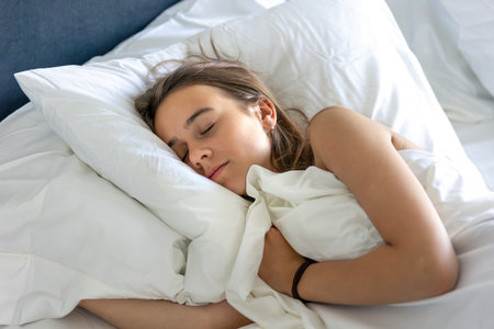 Girl on bed showing thumbs up and smiling.の写真素材