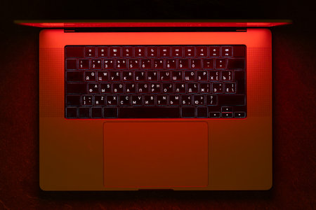 Red neon laptop for cybersecurity concepts. Dramatic tech mood.の写真素材