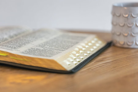 Open Bible with index tabs and a mug. Calm ritual.の写真素材