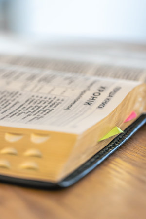 Bible spread with tabs in gentle light for spiritual focus. Bible detail.