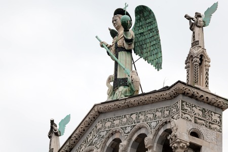 The 4 m-tall statue of St. Michael the Archangel on top of the San Michele in Foro, the Roman Catholic basilica church in Lucca, Tuscany, central Italyの写真素材