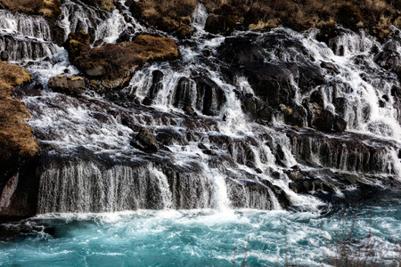 Hraunfossar in western Iceland is a series of waterfalls formed by rivulets streaming out of the...
