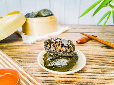 The tempting peanut-sesame-stuffed mugwort cake on the wooden tableの写真素材