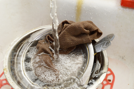 Dirty dishes and washcloth in the sinkの写真素材