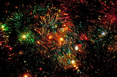 Tinsel and Christmas lights on dark background. Shallow depth of field