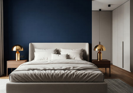 A modern and elegant bedroom with a dark blue accent wall and gold bedside lampsの素材
