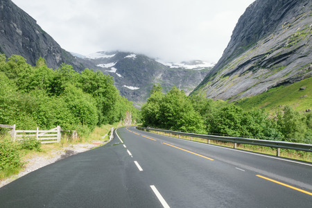 smooth asphalt road in the snowy mountainsの写真素材
