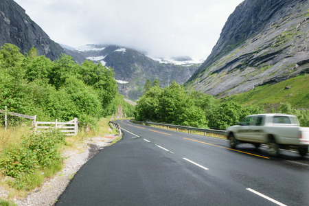 car on smooth asphalt road in the snowy mountainsの写真素材