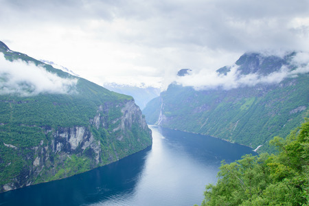 view of the rocky shore of Geiranger Fjord and waterfallの写真素材