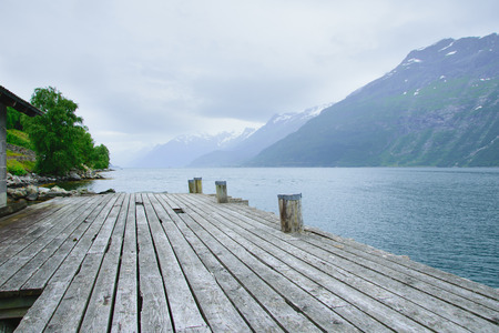 pier for boats on the shore of the fjord with the rocky shoresの写真素材