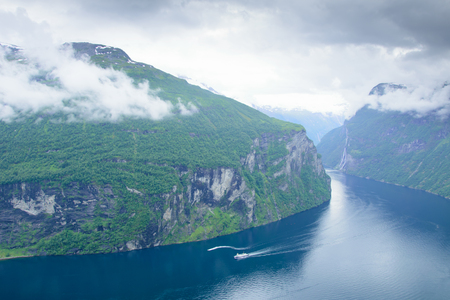 view of the rocky shore of Geiranger Fjord and waterfallの写真素材