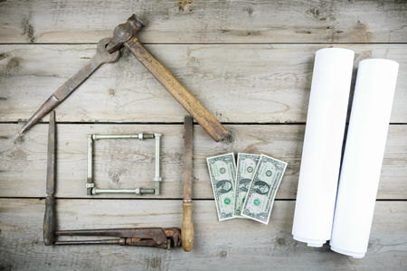 The concept of a house under construction. Old wooden desktop. Old rusty carpentry toolsの写真素材
