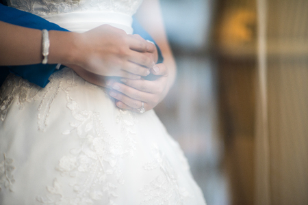 A look through the window on the hands of newlyweds hugging each other.の写真素材