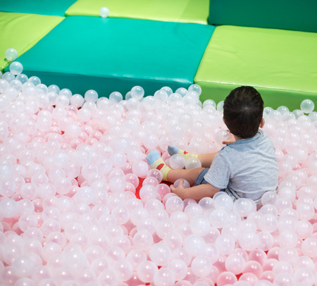 Little boy in monochromatic ball pit at indoor playgroundの写真素材