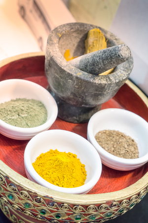 Close up Turmeric powder in white bowl on decorative herbal trayの写真素材