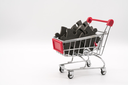 Shopping cart with black jigsaw puzzle inside.の写真素材