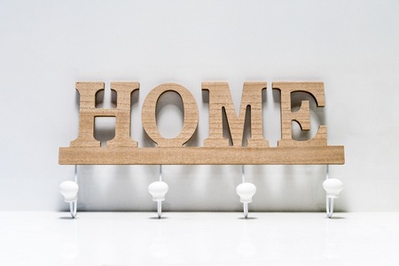 Wooden text "HOME" vintage hanger isolated on white backgroundの写真素材