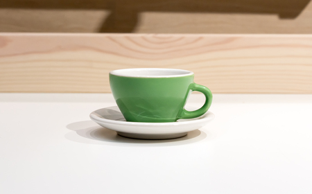Empty green coffee or tea mug or cup on wood and white table.の写真素材