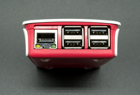 LAN and USB ports single-board computer in white and red plastic case isolated on black backgroundの写真素材