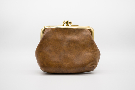 Brown leather purse isolated on white background. Old fashion wallet with antique metal edge.