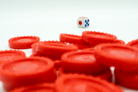 A pile of red coins and dice isolated on white background. Symbolic image for business or financial risk and oppotunity concept.   Perspective view.の写真素材