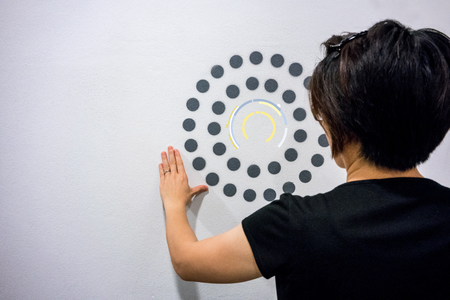 Woman using hands with dot graphic and circle diagram on white wall. Business info graphic interface design concept.の写真素材