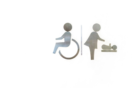 Wheelchair and women with baby, Changing diapers toilet metal sign on white backroundの写真素材