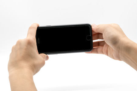 Female hand holding black cellphone with black screen isolated on white background.の写真素材